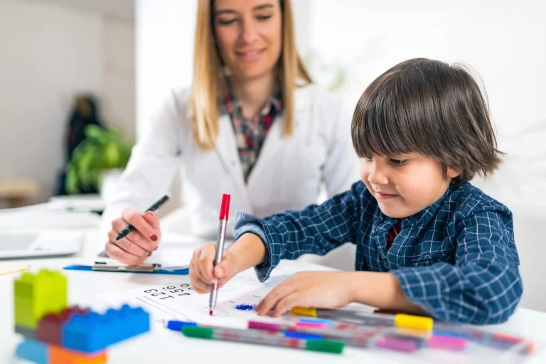 Pedagoga observa uma criança desenhar