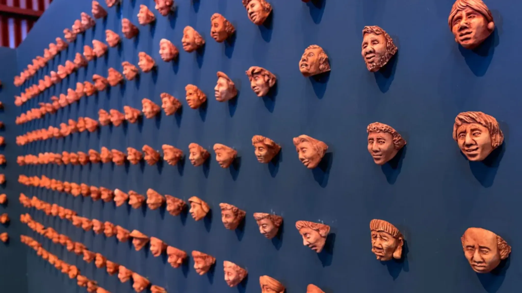 Criado pelo artista Bruno Souza, o painel de máscaras da Estrada de Ferro Madeira-Mamoré homenageia os trabalhadores que construíram a ferrovia. A obra foi produzida com o barro deixado pela enchente histórica do Rio Madeira, em 2014.