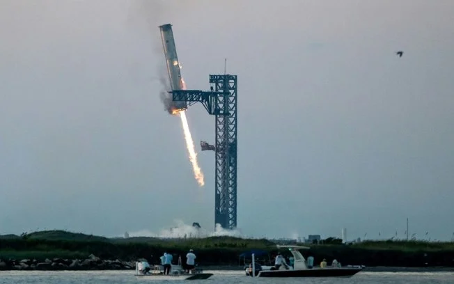 O propulsor SuperHeavy retorna à base da SpaceX no Texas, em 13 de outubro de 2024 O propulsor SuperHeavy retorna à base da SpaceX no Texas, em 13 de outubro de 2024