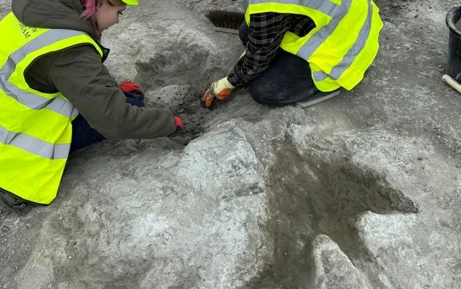 Uma fotografia tirada pela paleontóloga de vertebrados, Dra. Emma Nicholls, e divulgada pela Universidade de História Natural de Oxford em 2 de janeiro de 2025, mostra membros da equipe de escavação trabalhando nas pegadas na Dewars Farm Quarry Uma fotografia tirada pela paleontóloga de vertebrados, Dra. Emma Nicholls, e divulgada pela Universidade de História Natural de Oxford em 2 de janeiro de 2025, mostra membros da equipe de escavação trabalhando nas pegadas na Dewars Farm Quarry