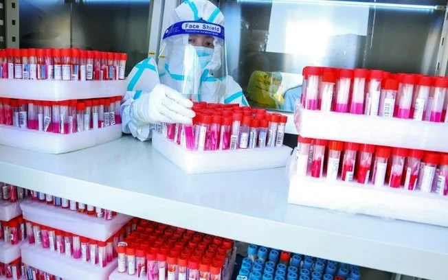Técnico de laboratório manipula amostras em uma unidade de testes para a covid-19 Técnico de laboratório manipula amostras em uma unidade de testes para a covid-19