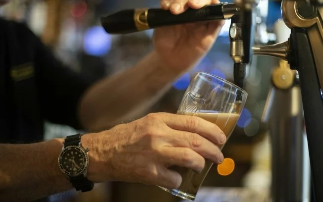 Um barman serve uma cerveja de pressão em um bar em Brest, oeste da França Um barman serve uma cerveja de pressão em um bar em Brest, oeste da França