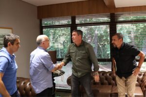 Governador de camisa verde cumprimenta Radamés Lattari, que está de camisa azul claro.