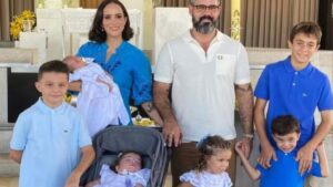 Juliano Cazarré posa ao lado da esposa e filhos no batizado do caçula