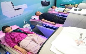 Três pessoas dormem em uma sala de descanso na feira de Xangai dedicada ao cuidado de idosos e à reabilitação médica, em 13 de junho de 2024