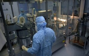Dois técnicos trabalham no laboratório de embalagens da Sinergium Biotech, no dia 22 de setembro de 2021 na localidade argentina de Garín, na província de Buenos Aires