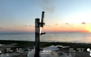 Esta imagem capturada de uma transmissão da SpaceX mostra o propulsor Super Heavy sendo capturado no ar enquanto retorna à plataforma de lançamento, na base de Boca Chica, Texas, em 13 de outubro de 2024