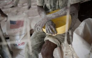 Um trabalhador humanitário distribui farinha fornecida pela USAID em um centro de refugiados perto de Dadaab, no Quênia, em uma foto de arquivo de 2011