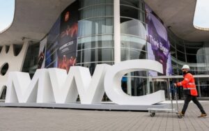 Um trabalhador passa pela entrada da Feira Barcelona, onde se realiza o Mobile World Congress (MWC), o maior evento de conetividade do mundo, em Barcelona, em 27 de fevereiro de 2025