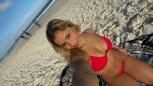 Flavia Saraiva posa de biquíni com álbum de fotos na praia