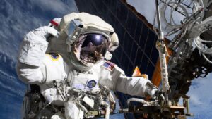Astronauta da NASA, Anne McClain, perto de um dos principais painéis solares da Estação Espacial Internacional